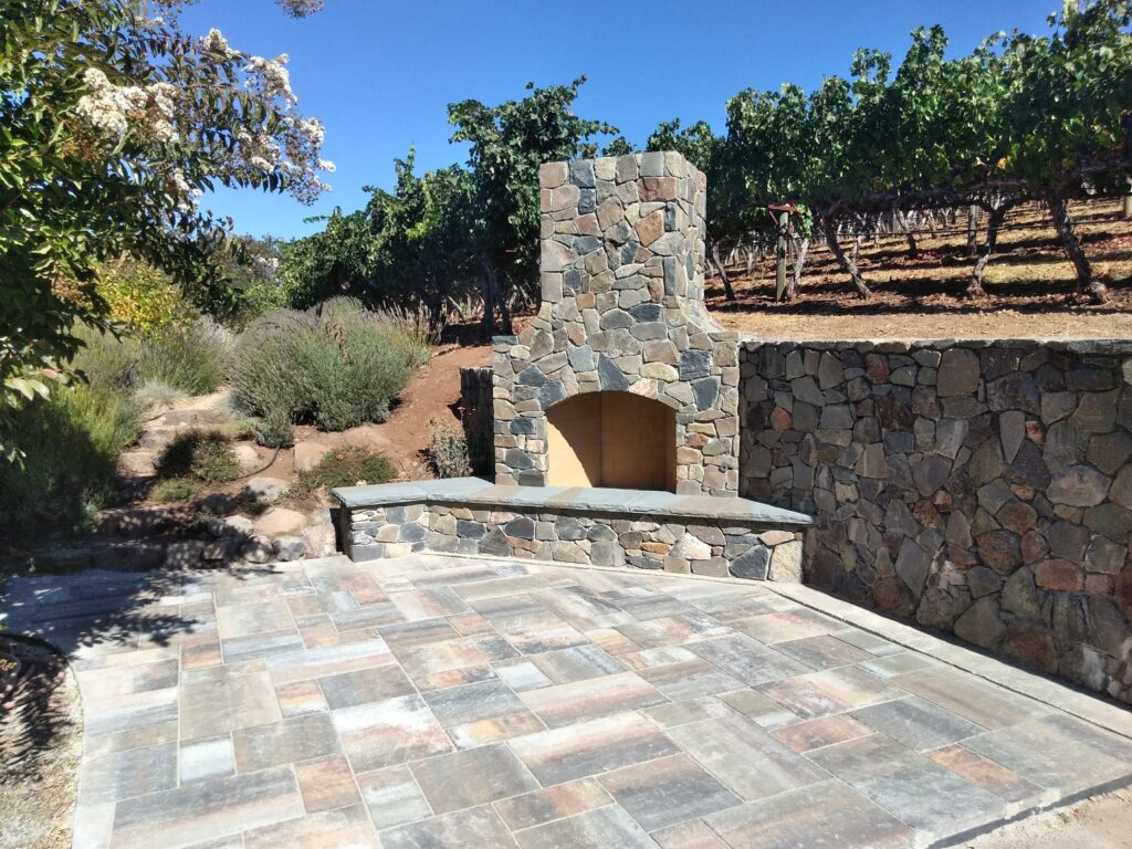 Outdoor stone fireplace in a vineyard setting