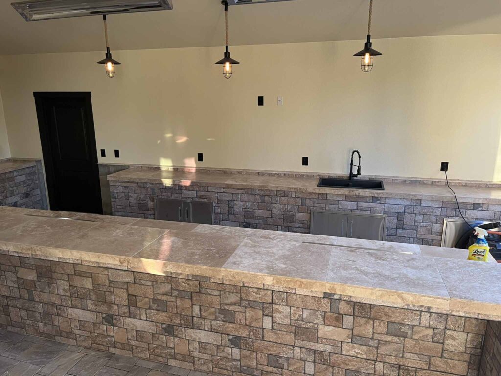 Outdoor kitchen with stone counter and bar seating